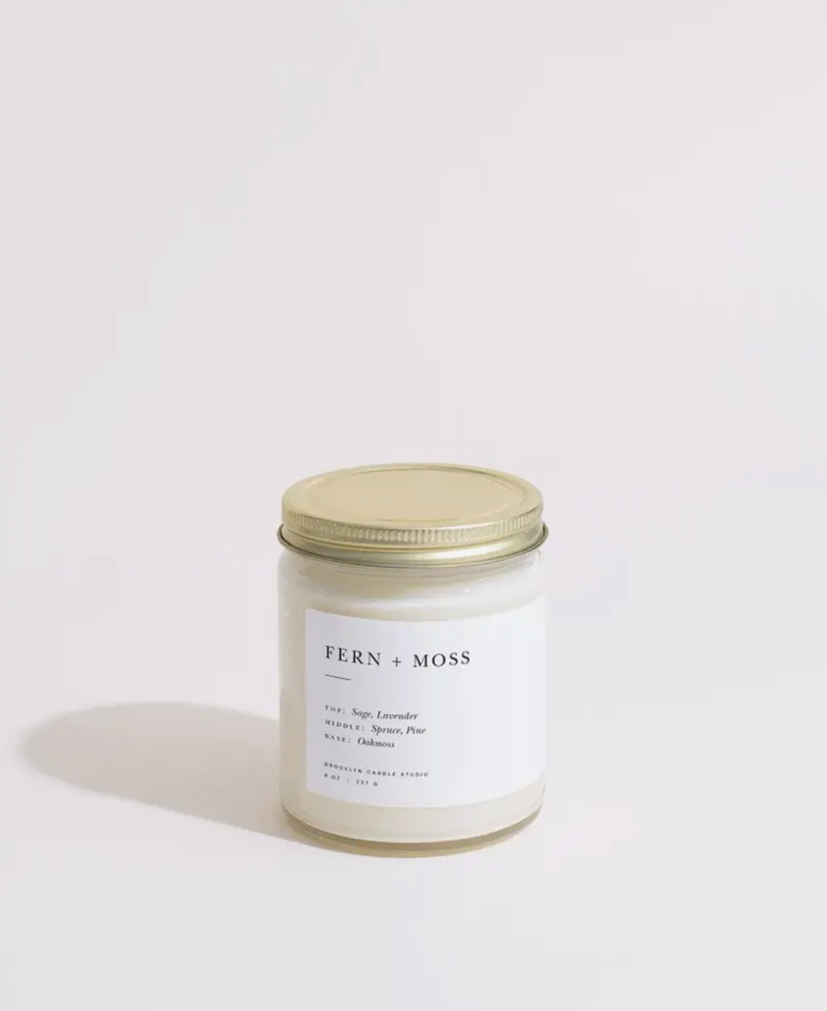 Fern & Moss candle with a gold lid on a white background