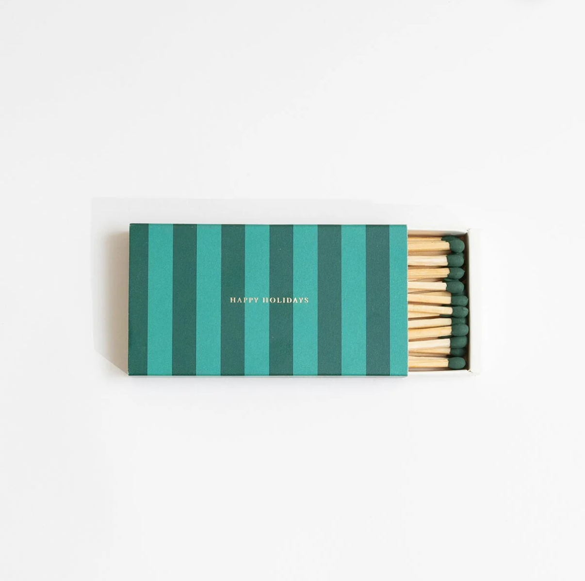 Matchbox with green and teal striped design and 'Happy Holidays' text on a white background
