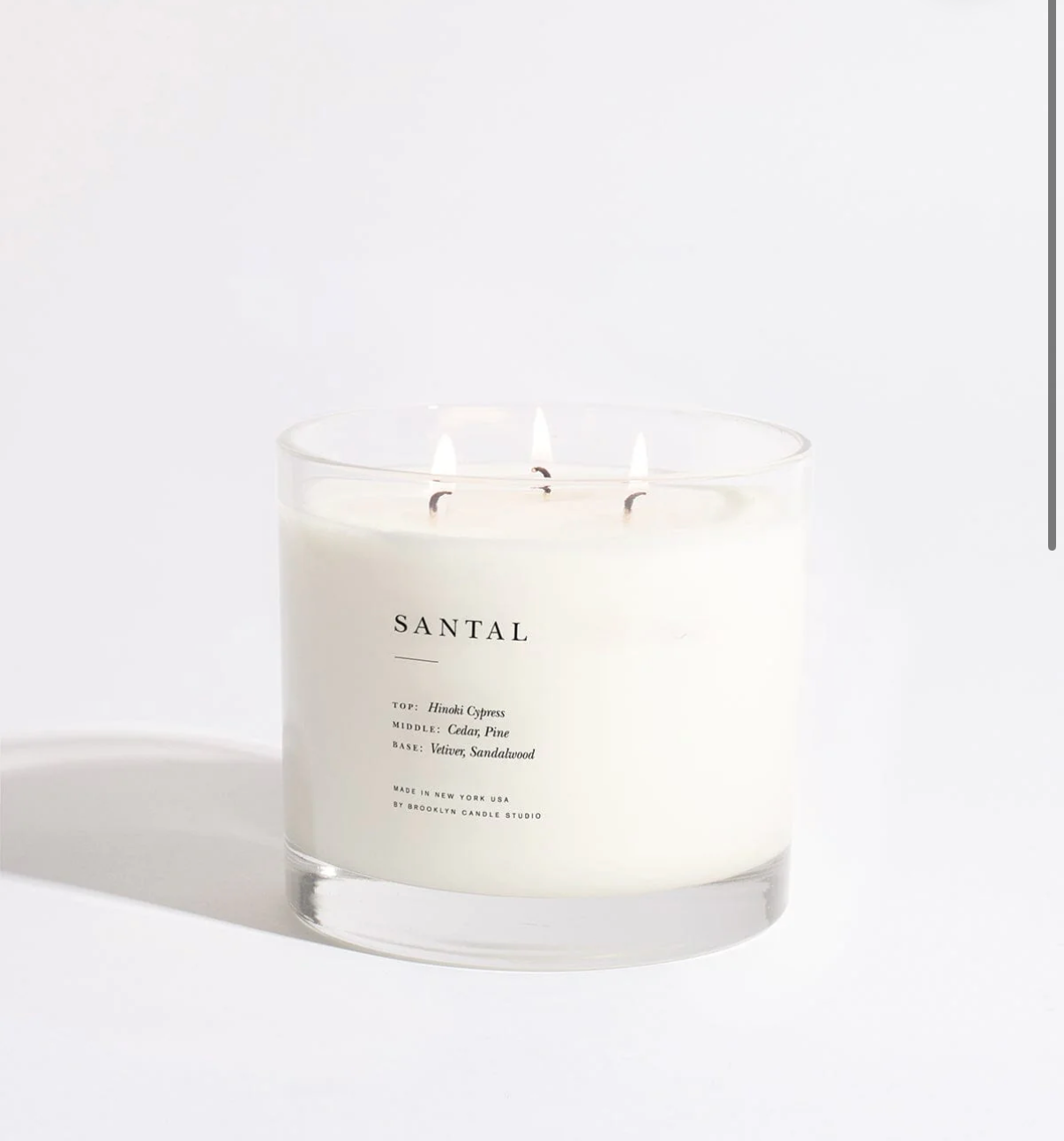 Santal candle with a white label on a light gray background