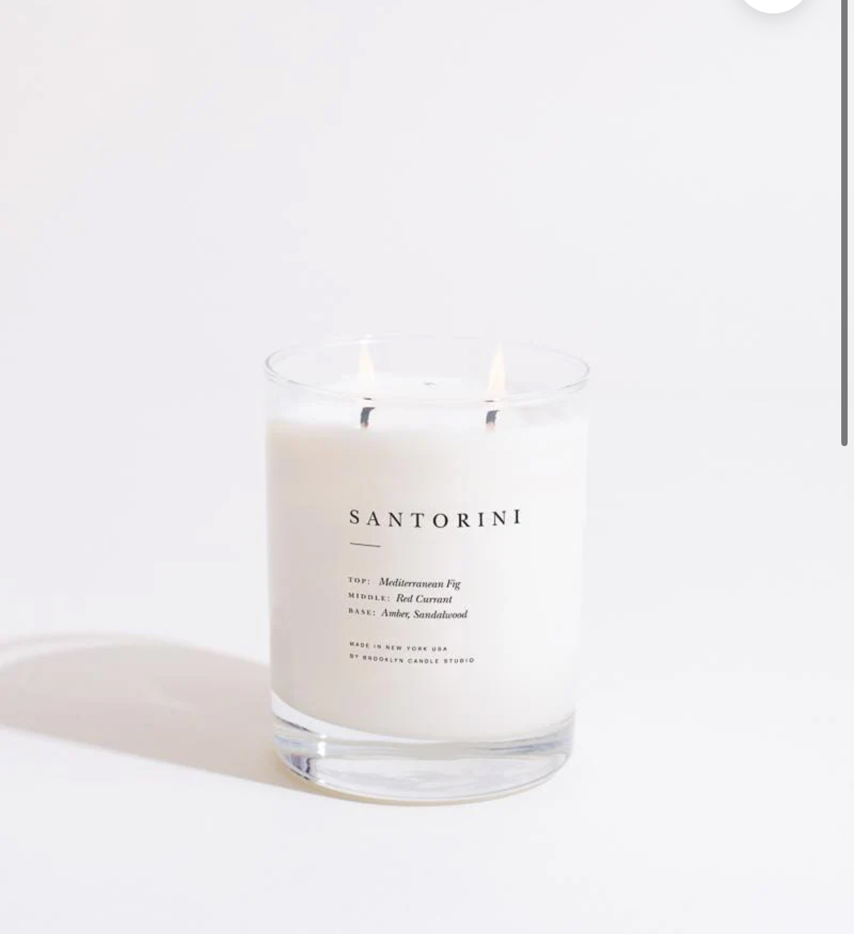 Santorini candle in a glass jar on a white background