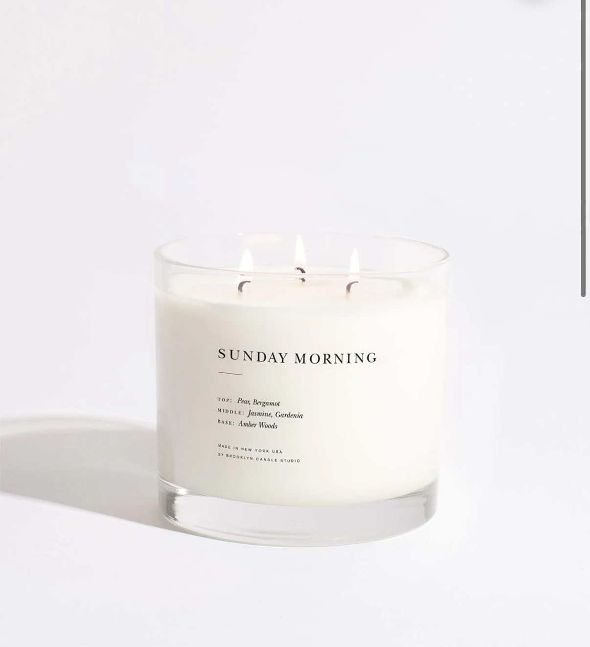 Candle labeled 'Sunday Morning' on a white background