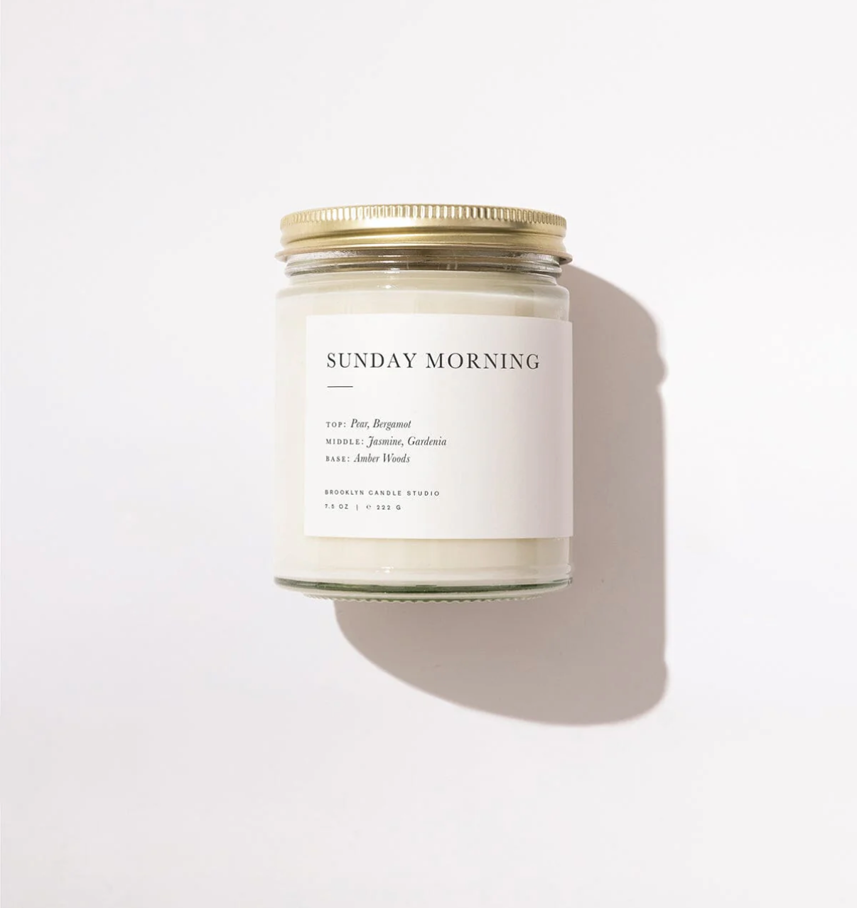 Candle jar labeled 'Sunday Morning' on a white background