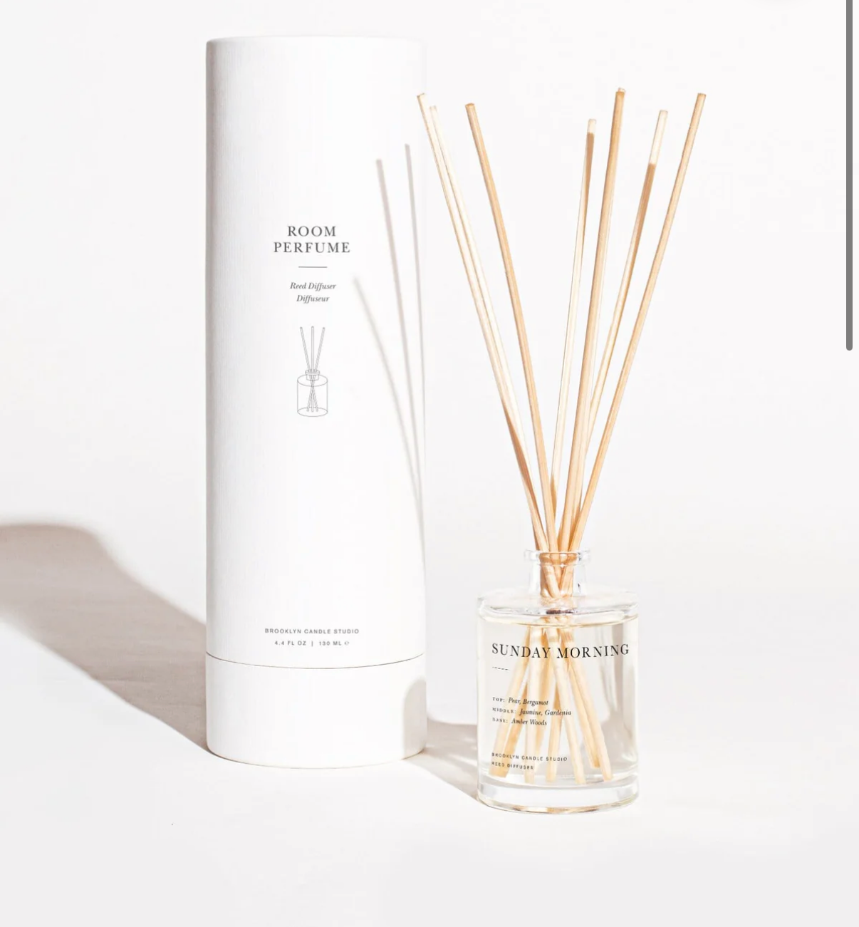Room perfume with sticks and packaging on a white background