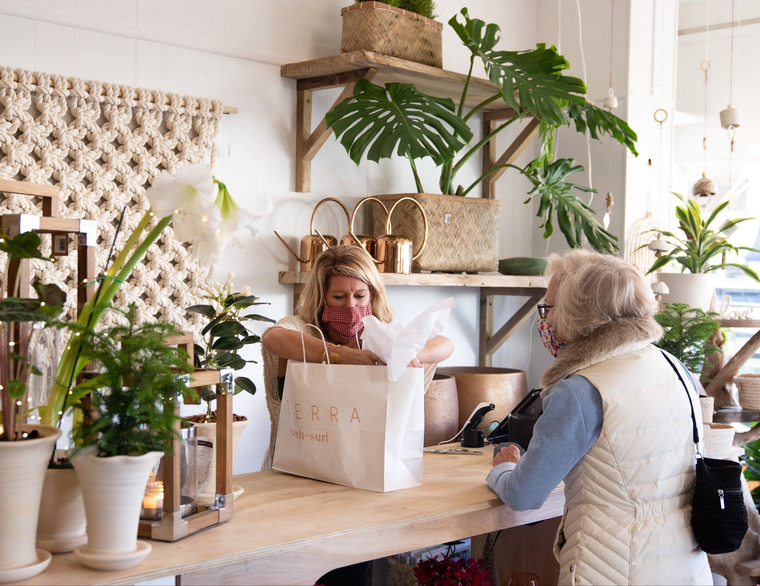 Two women in a store with plants and decor